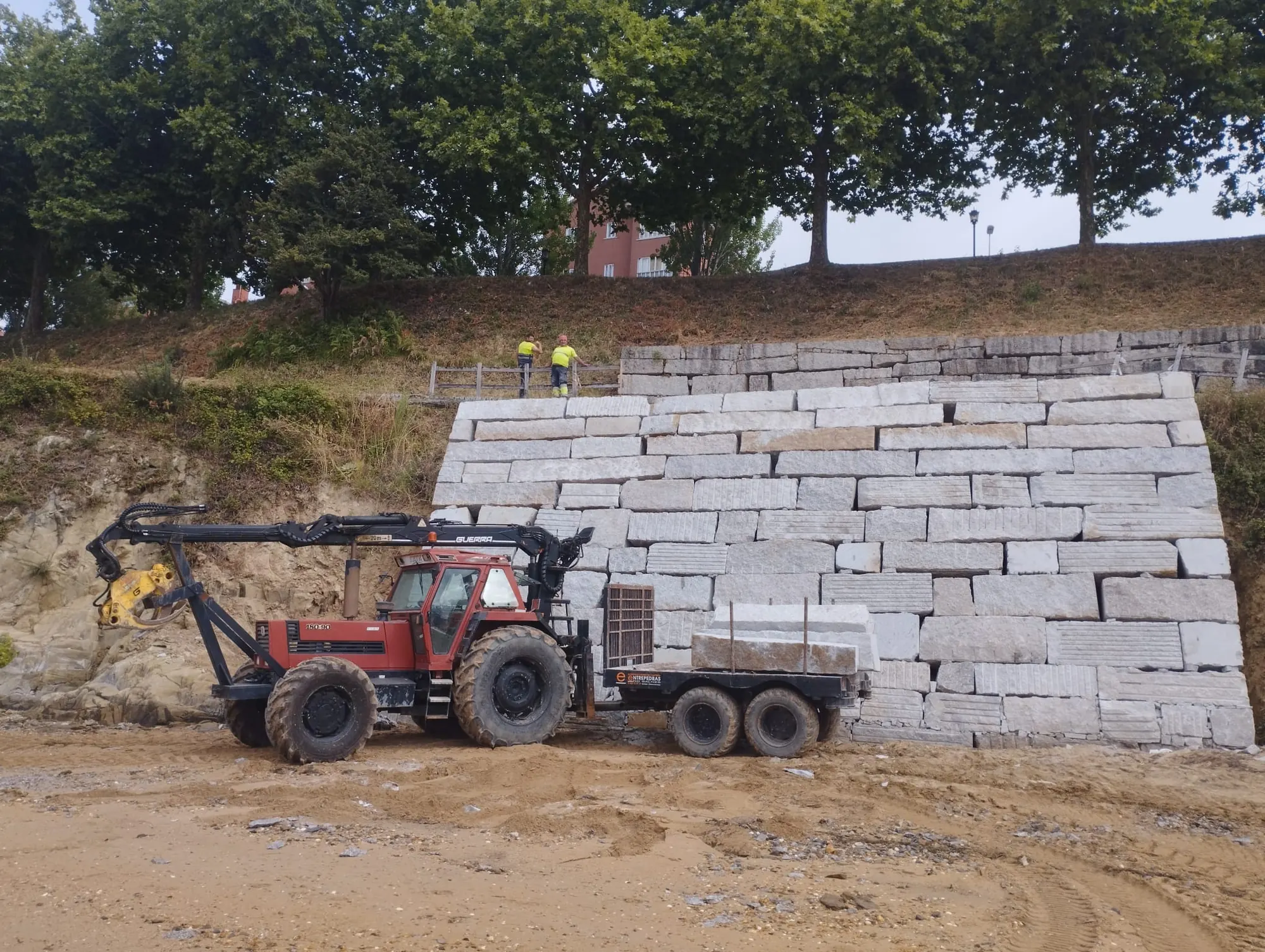 Maquinaria trabajando en la ejecución de un muro de piedra